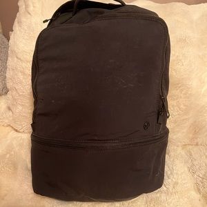 Lululemon black backpack, worn in with minor wearing on front and sides